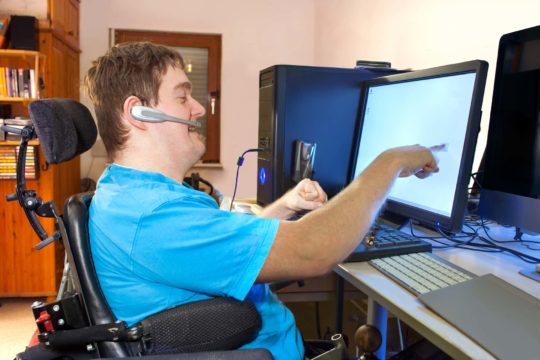 Young person with cerebral palsy using a computer