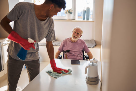 Care worker cleaning speaking with client