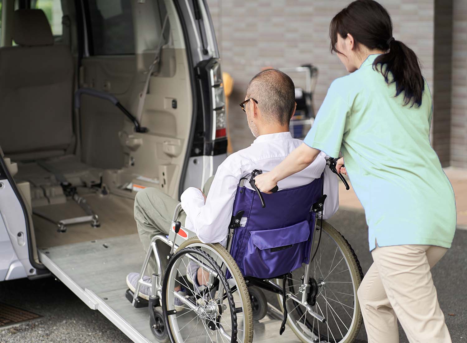 Careworker helping client into transport