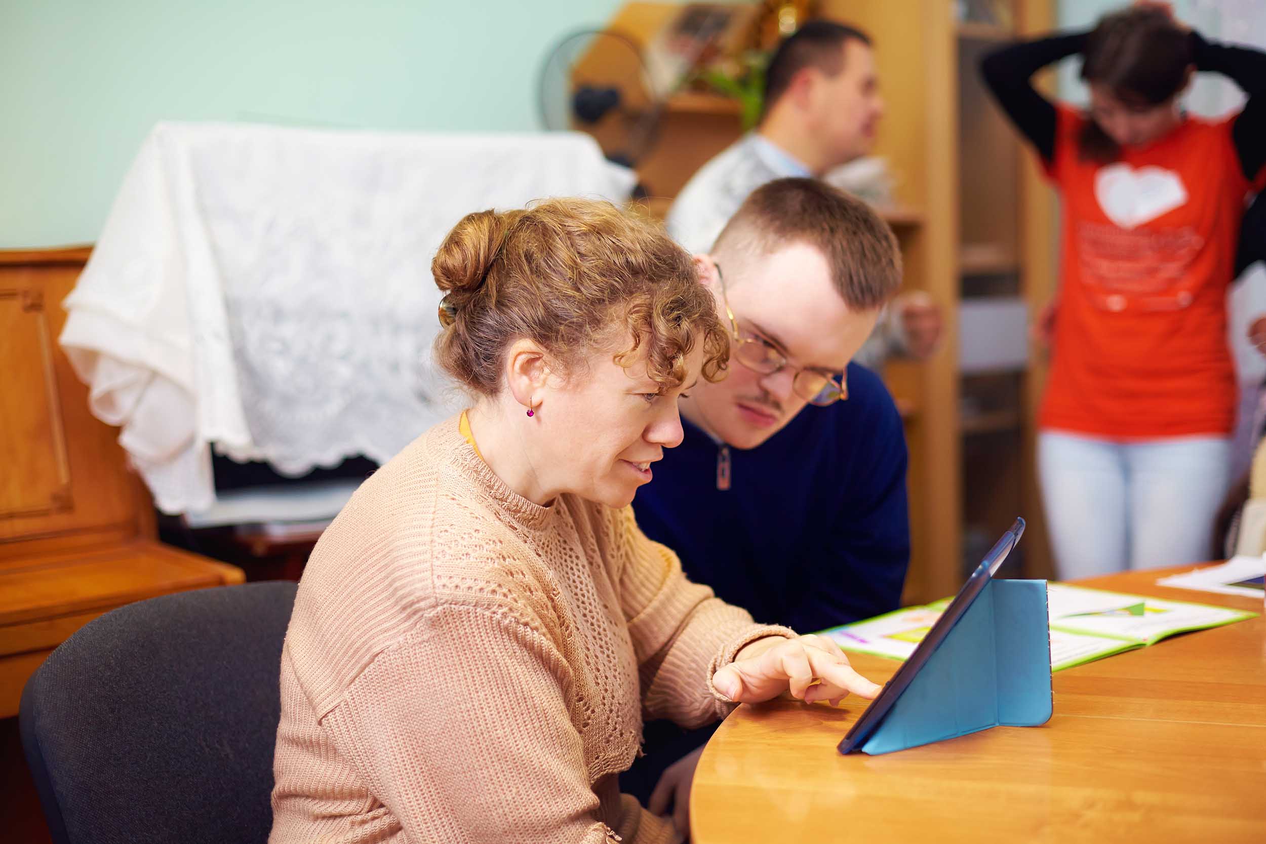 two friends in rehabilitation centre watching digital tablet