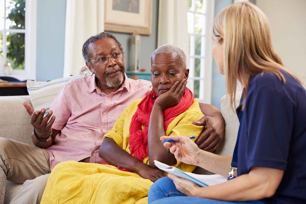 elderly couple speaking with health professional