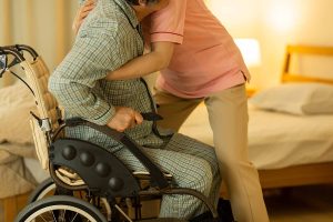care worker lifting person out of wheelchair