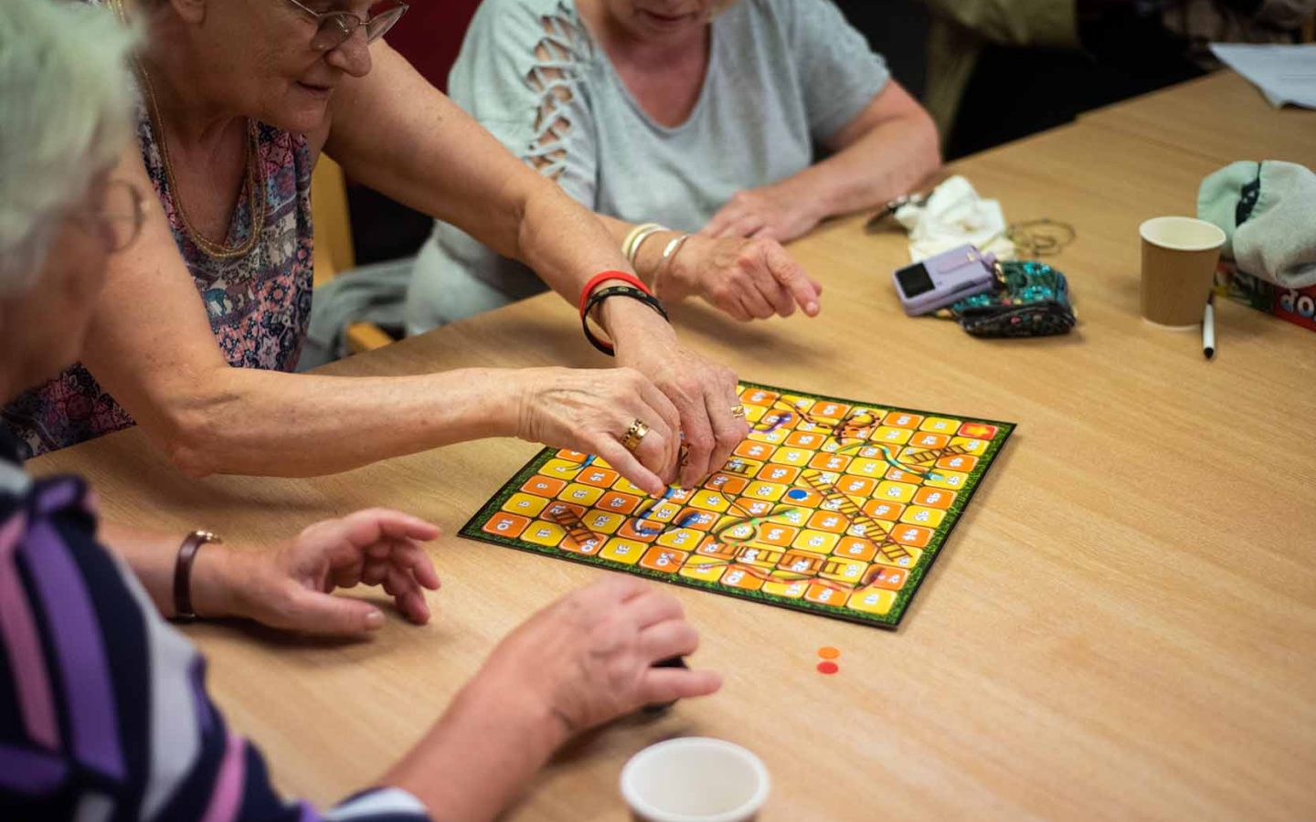 three People playing board game in care environment.