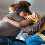 Young person embracing adult in wheelchair