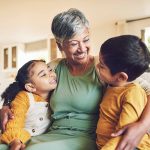 Grandparent with two children, smiling