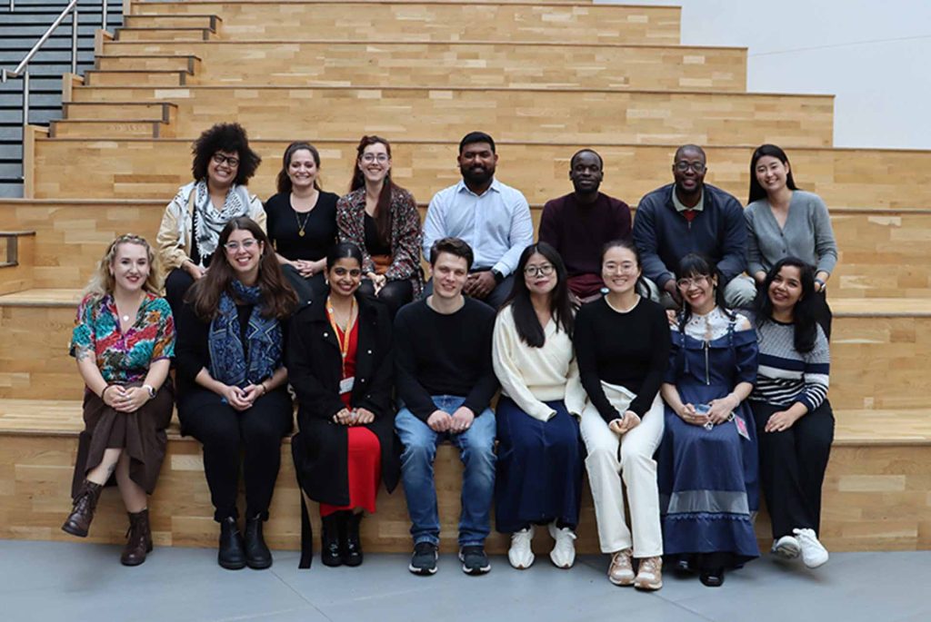14 students sitting on indoor steps