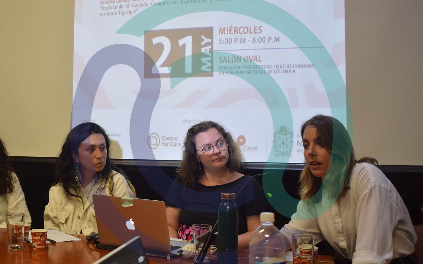 Three people presenting research in front of a projected screen