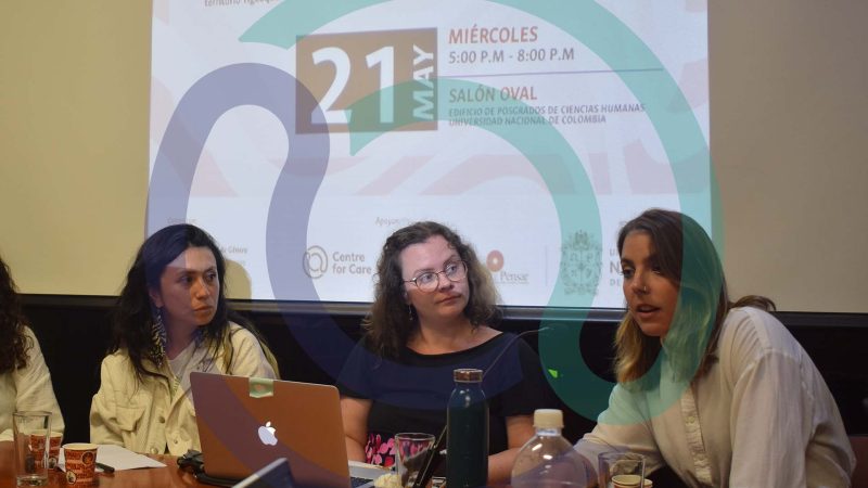 Three people presenting research in front of a projected screen
