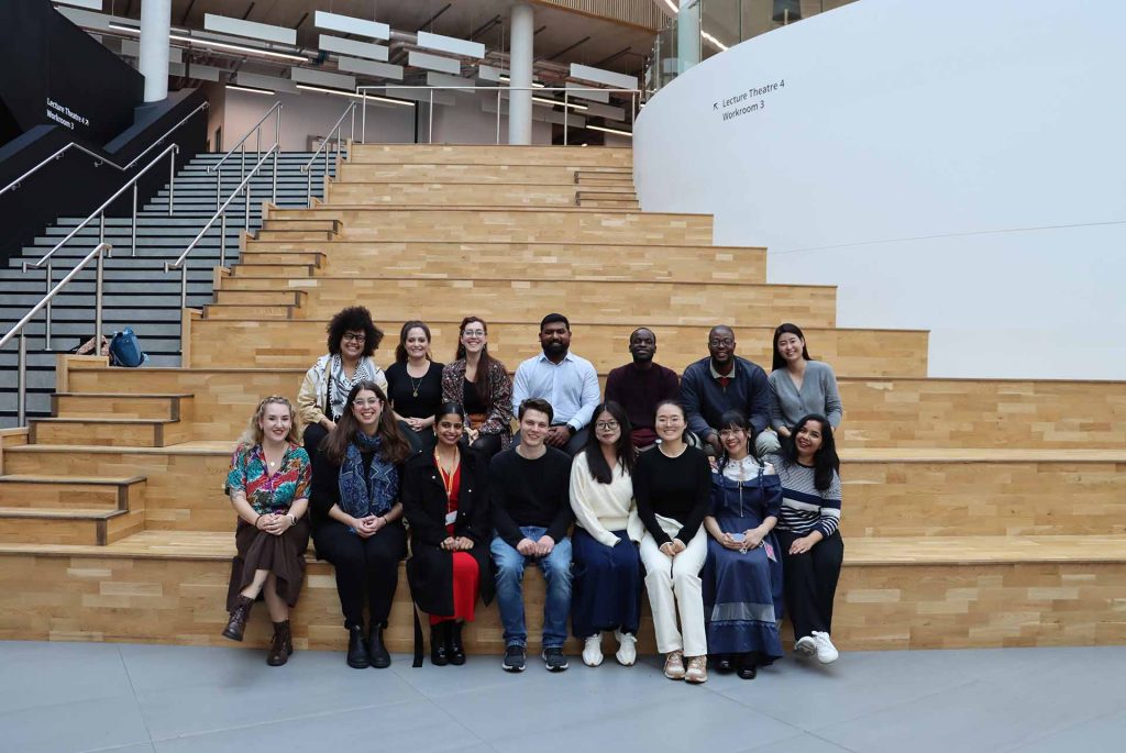 14 students sitting on indoor steps