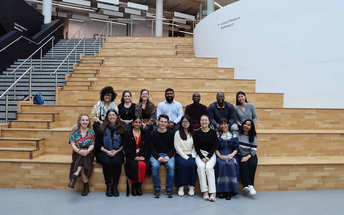 14 students sitting on indoor steps
