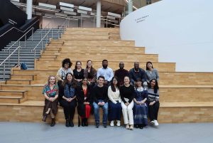 14 students sitting on indoor steps