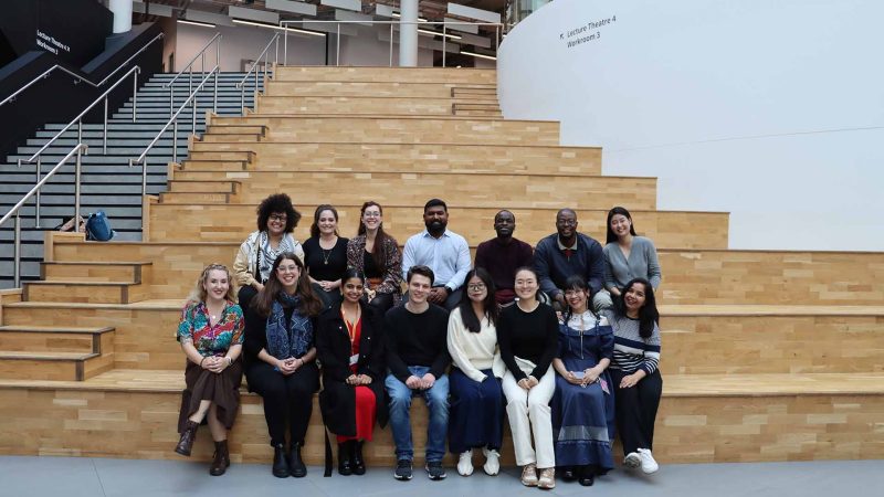 14 students sitting on indoor steps