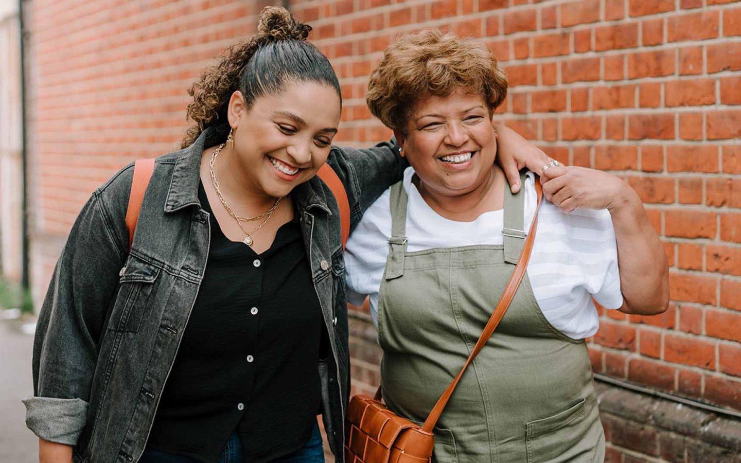 two people with arms around each other smiling