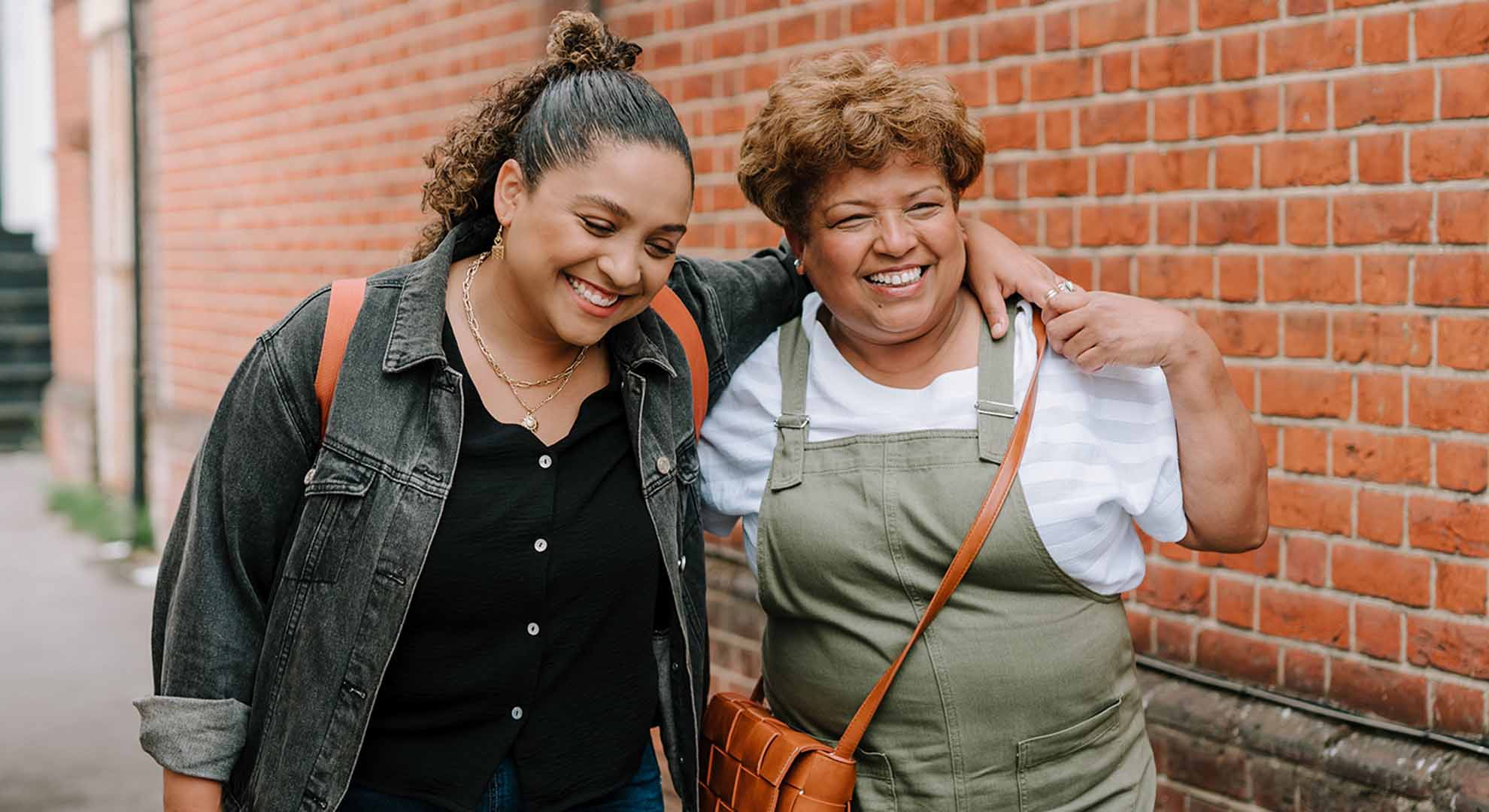two people with arms around each other smiling