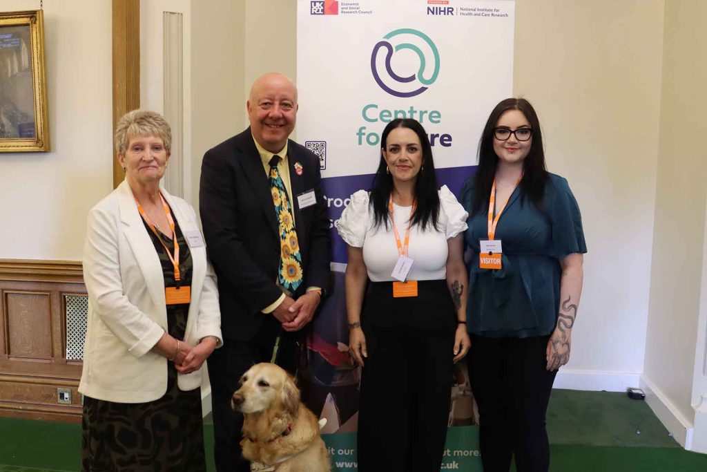 4 people posing for photo inf front of Centre for Care banner