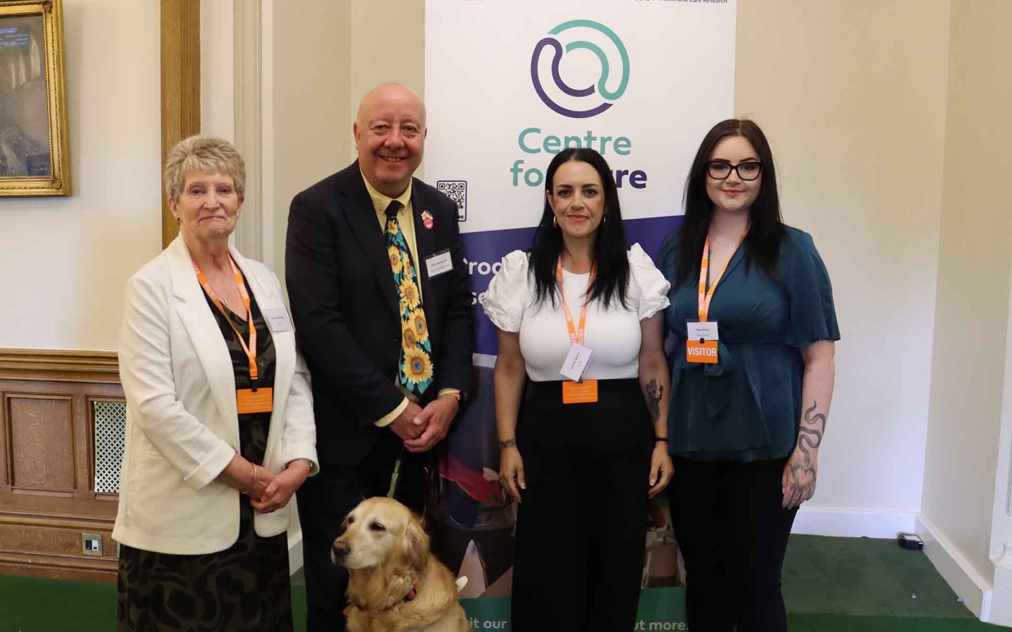 4 people posing for photo inf front of Centre for Care banner