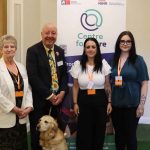 4 people posing for photo inf front of Centre for Care banner