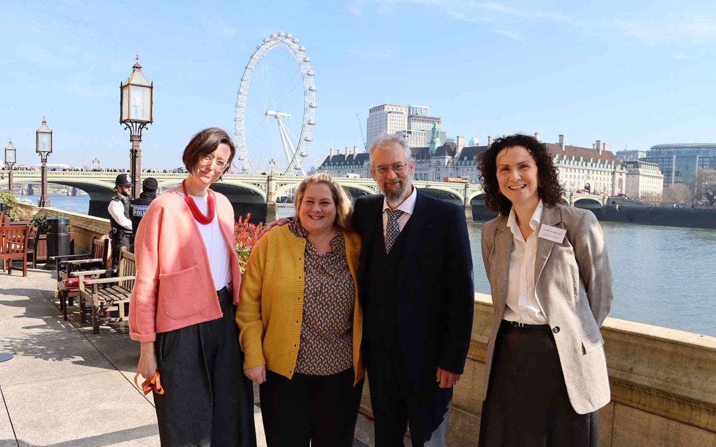 people by the side of the Thames river outside Parliament