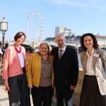 people by the side of the Thames river outside Parliament