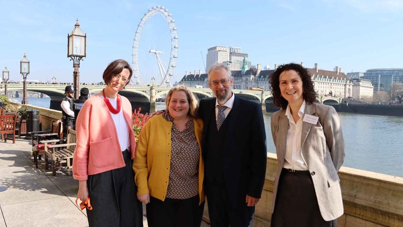 people by the side of the Thames river outside Parliament