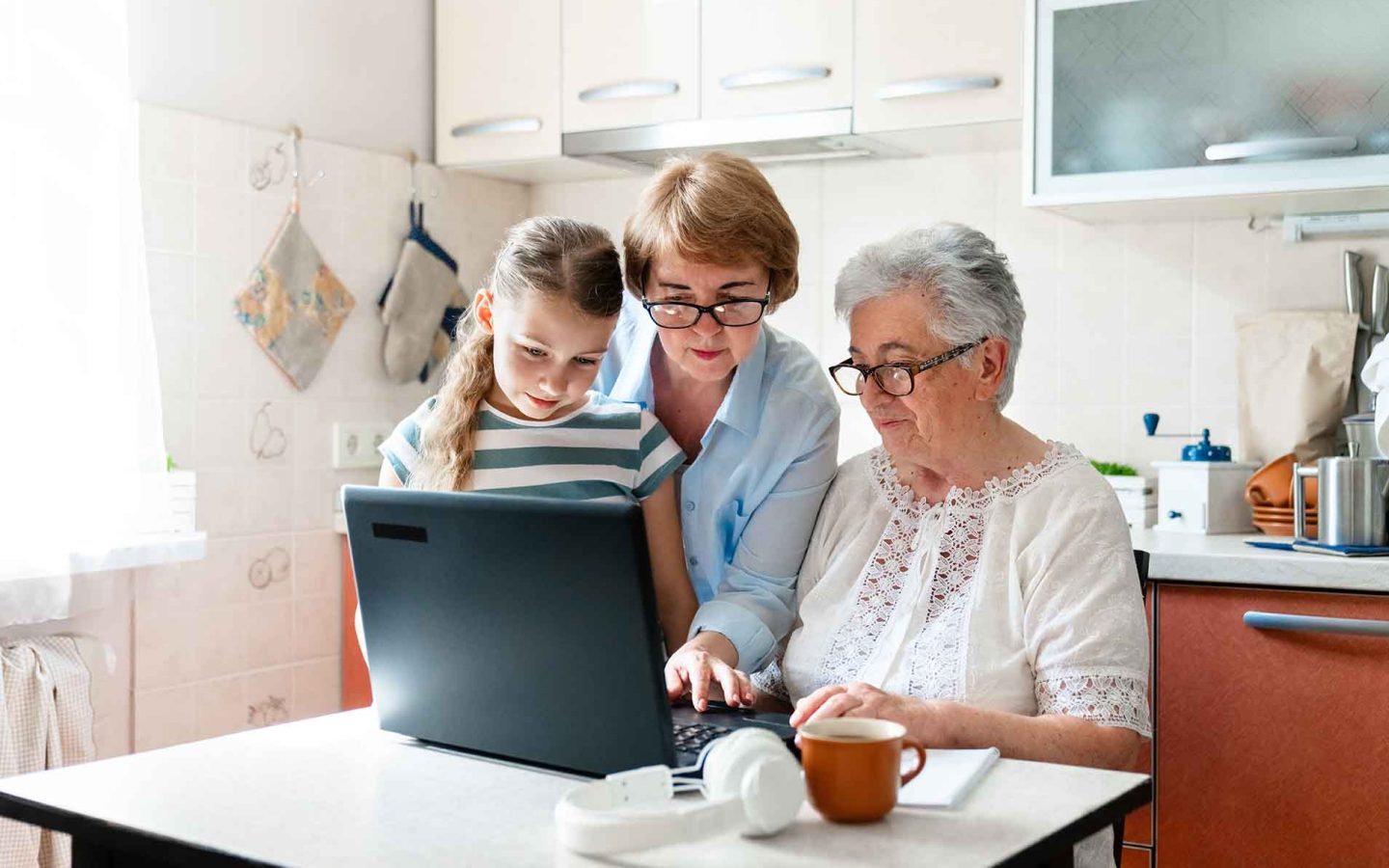three people of different generations using a laptop