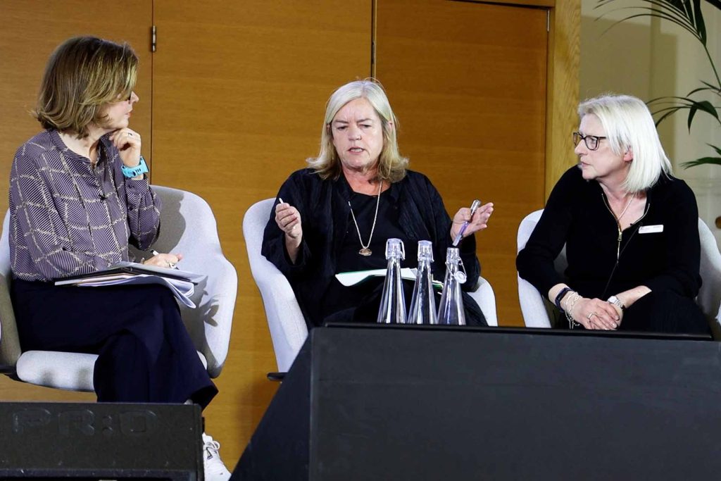 Jane Hill, Baroness Louise Casey and Helen Walker  in conversation, sitting in chairs on a stage.