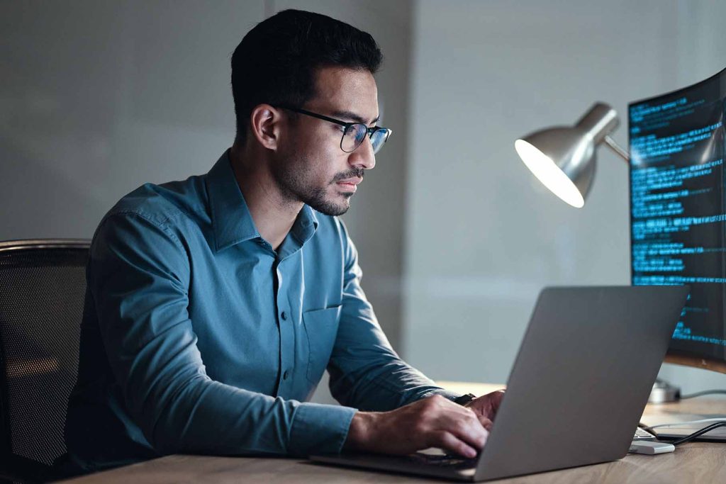 person wearing glasses sitting at computer