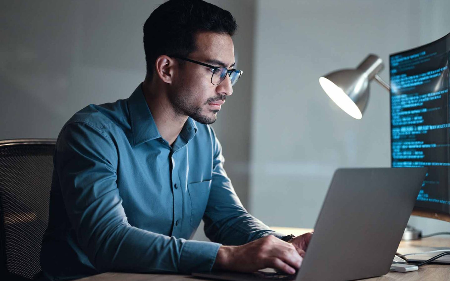 person wearing glasses sitting at computer