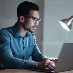 person wearing glasses sitting at computer
