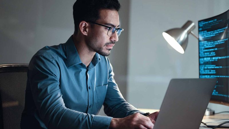 person wearing glasses sitting at computer